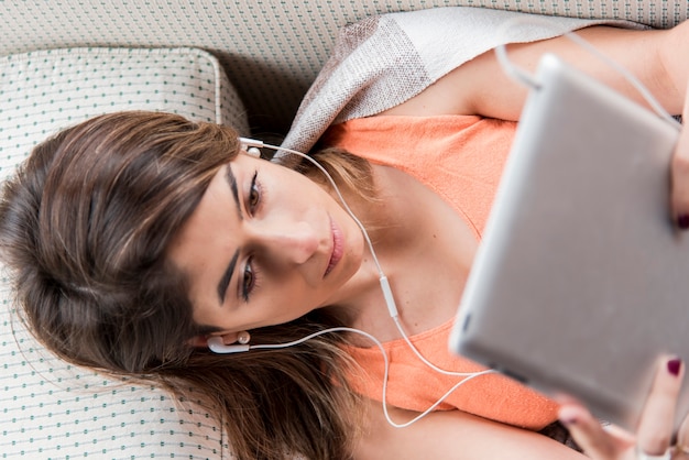 Vue de dessus femme avec tablette et casque