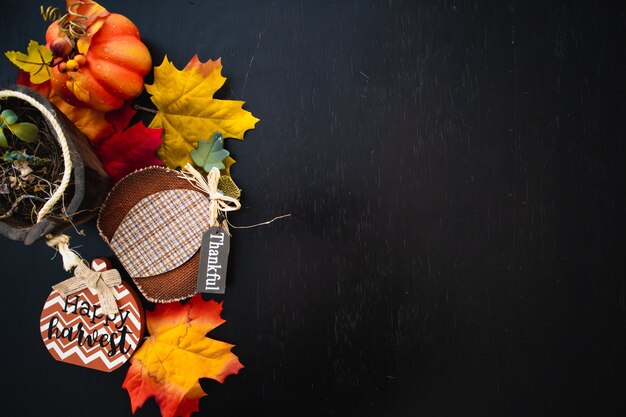 Vue de dessus des feuilles d'érable d'automne avec de la citrouille sur une surface en bois noire