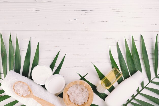 Vue de dessus des feuilles tropicales avec des outils de beauté et des produits de beauté