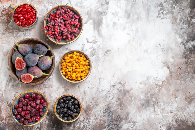 Vue de dessus des figues fraîches avec d'autres fruits sur fond clair