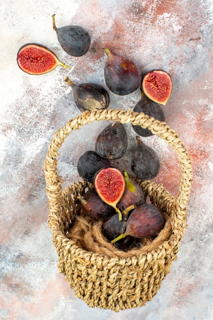 Vue de dessus des figues fraîches éparpillées du panier sur fond nu