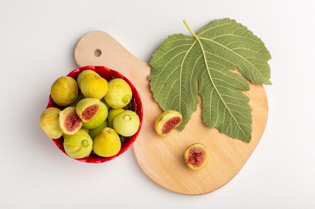 Vue de dessus figues sucrées fraîches délicieux fœtus à l'intérieur de la plaque rouge sur backgorund blanc fruit arbre frais plante douce douce