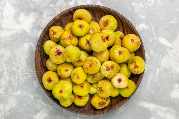 Vue de dessus figues sucrées fraîches à l'intérieur de la plaque brune sur le bureau léger