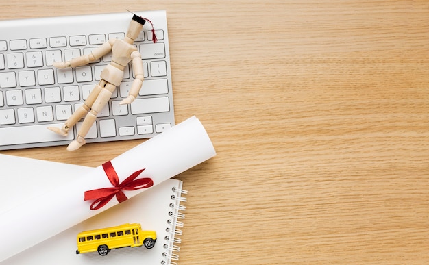 Photo gratuite vue de dessus de la figurine en bois avec capuchon académique et livres