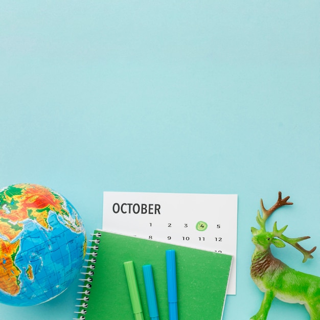 Vue de dessus de la figurine de cerf avec calendrier et planète terre pour la journée des animaux