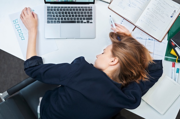 Photo gratuite vue de dessus fille allongée sur le bureau