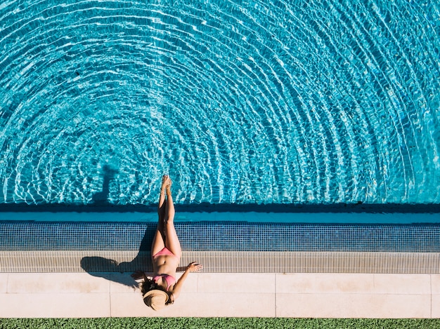 Vue de dessus d&#39;une fille se détendre à côté de la piscine