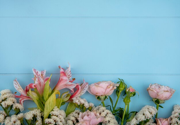 Vue de dessus de fleurs rose clair sur une surface bleu clair