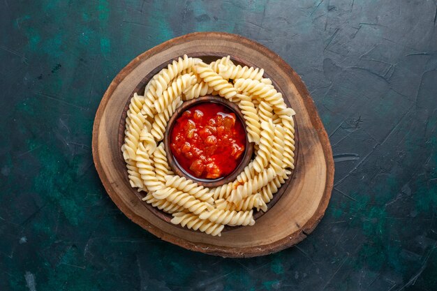 Vue de dessus en forme de pâtes italiennes avec sauce tomate sur fond bleu foncé