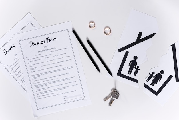 Vue de dessus des formulaires de divorce avec les clés de la maison et les alliances