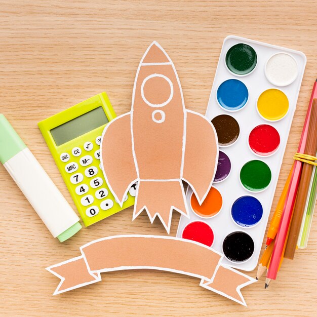Vue de dessus des fournitures scolaires avec aquarelle et calculatrice
