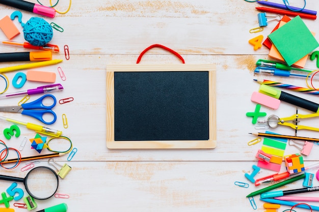 Vue de dessus des fournitures scolaires sur une table en bois blanc