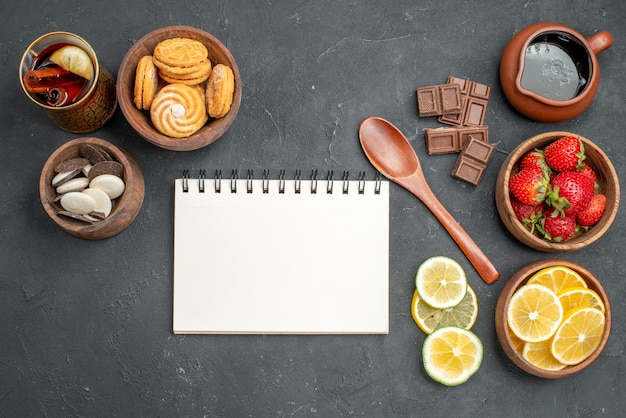 Photo gratuite vue de dessus fraises et citrons de fruits frais avec des biscuits sur une surface grise