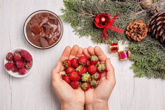 Vue de dessus des fraises fraîches au chocolat sur un tableau blanc