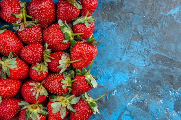 Vue de dessus des fraises rouges sur fond bleu