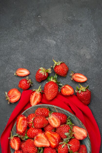 Vue de dessus des fraises rouges fraîches à l'intérieur de la plaque sur fond sombre