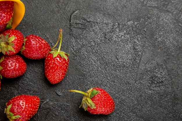 Vue de dessus fraises rouges fraîches sur sol sombre baies de fruits mûrs