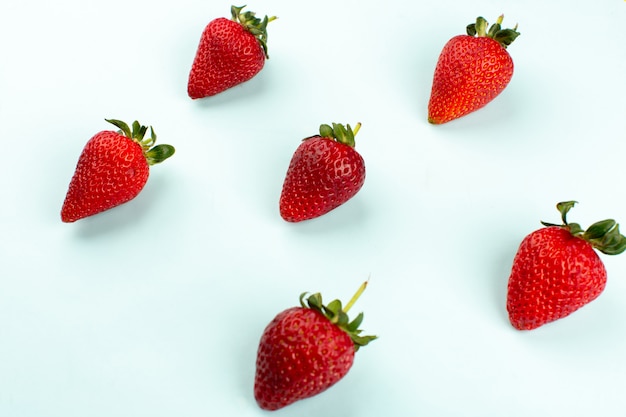 Vue de dessus des fraises rouges moelleux frais juteux isolé sur le sol blanc