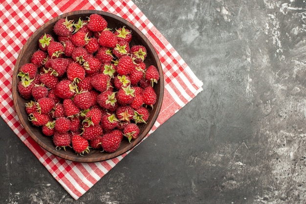 Vue de dessus des framboises rouges fraîches à l'intérieur de la plaque sur fond gris