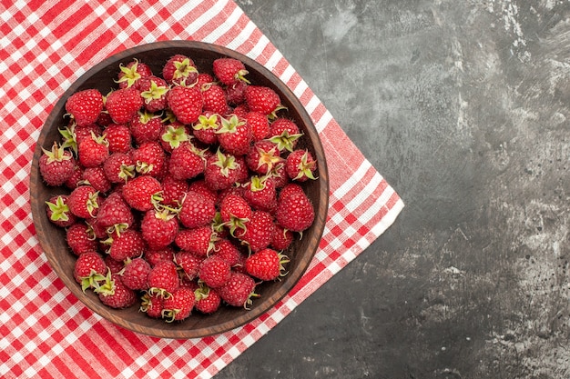 Vue de dessus des framboises rouges fraîches à l'intérieur de la plaque sur fond gris