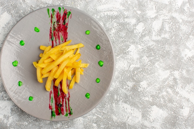 Photo gratuite vue de dessus des frites cuites et salées à l'intérieur de la plaque sur le bureau gris clair