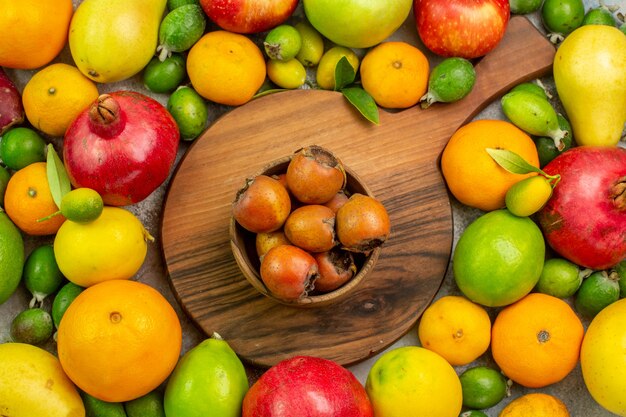 Vue de dessus des fruits frais différents fruits mûrs et moelleux sur fond blanc couleur berry photo santé régime savoureux