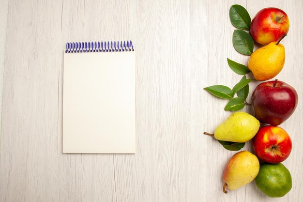 Vue de dessus fruits frais pommes et poires sur bureau blanc fruits mûrs arbre couleur moelleux beaucoup de frais