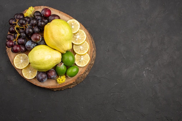 Vue de dessus fruits frais raisins tranches de citron prunes et coings sur surface sombre fruits plante arbre mûr frais