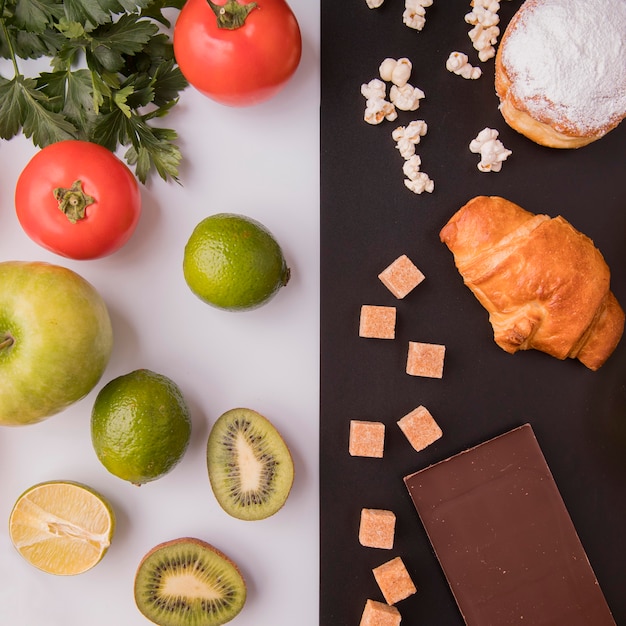 Vue de dessus des fruits et légumes par rapport aux bonbons malsains