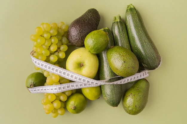 Vue de dessus des fruits et légumes verts attachés avec un ruban à mesurer