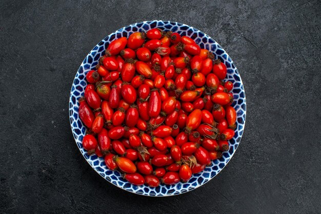 Vue de dessus fruits rouges mûrs et baies aigres sur le bureau gris