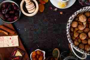 Photo gratuite vue de dessus des fruits secs aux noix, tablettes de chocolat et épices sur fond noir avec copie espace