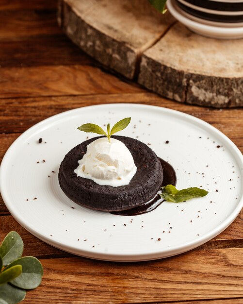 Une vue de dessus un gâteau au chocolat avec de la crème à l'intérieur de la plaque sur la table en bois brun gâteau dessert chocolat