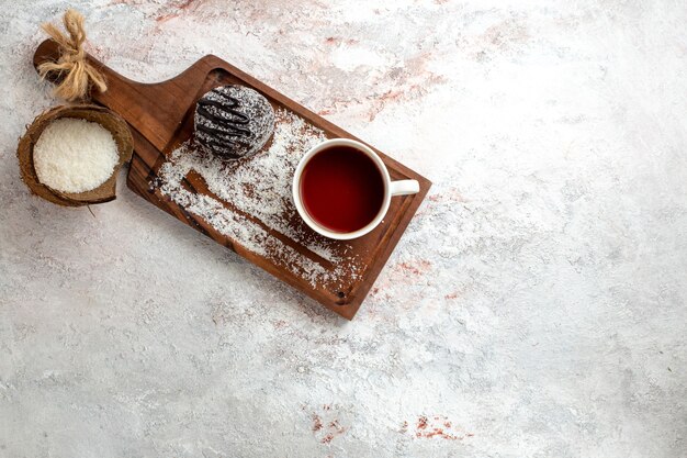 Vue de dessus gâteau au chocolat avec tasse de thé sur fond blanc gâteau au chocolat biscuit sucre biscuit sucré thé