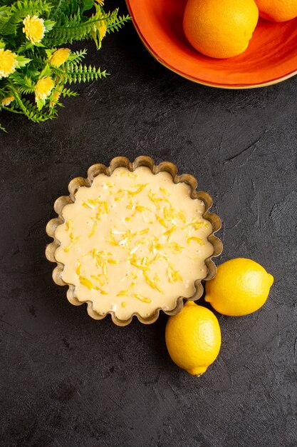 Une vue de dessus gâteau au citron aigre délicieux gâteau de boulangerie exotique sucré sur le bureau sombre