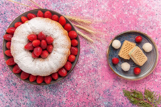 Vue de dessus gâteau aux fraises tarte en poudre de sucre avec des gaufres sur le rose