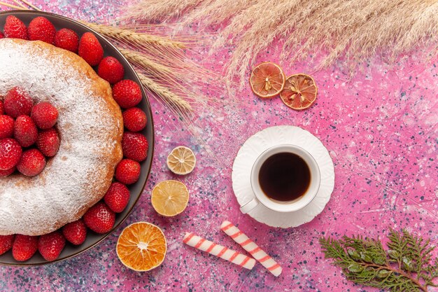 Vue de dessus gâteau aux fraises tarte en poudre de sucre avec tasse de thé sur rose