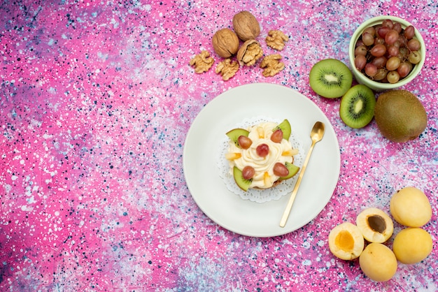 Vue de dessus gâteau à la crème aux noix de fruits frais sur le fond violet gâteau de couleur biscuit sucré