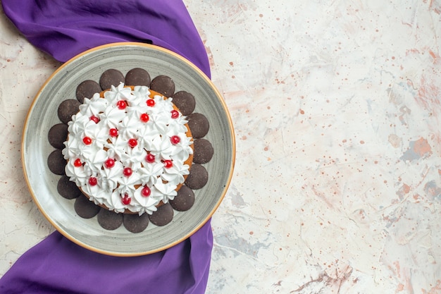 Vue de dessus gâteau avec crème pâtissière sur plaque châle violet