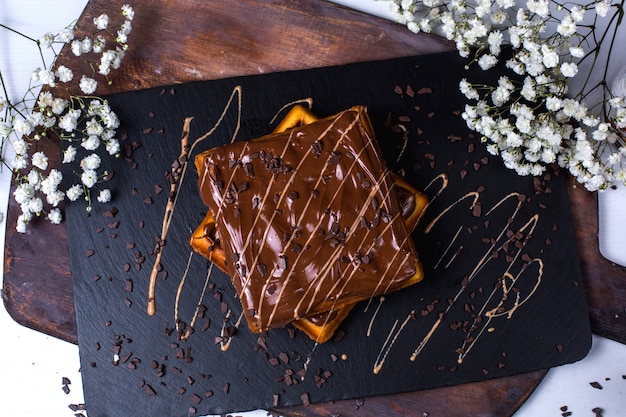 Vue de dessus de la gaufre belge au chocolat sur une planche de bois