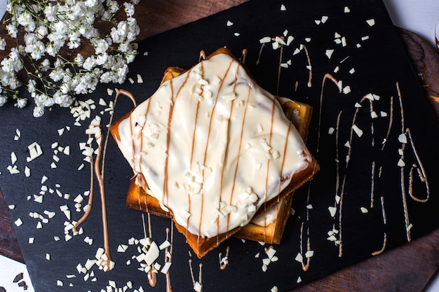 Vue de dessus de la gaufre belge avec du chocolat blanc sur la table