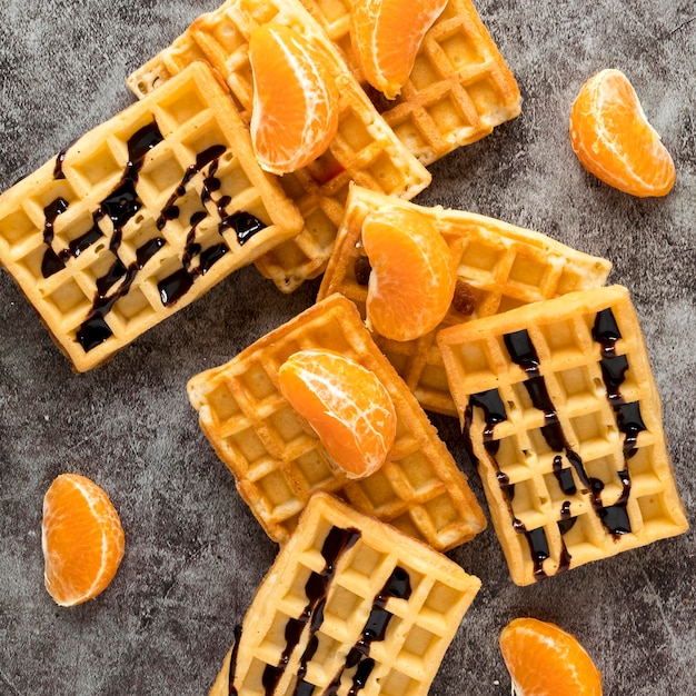 Photo gratuite vue de dessus des gaufres aux mandarines et sauce au chocolat