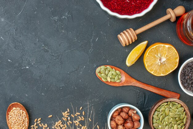 Vue de dessus de la gelée fruitée rouge avec des cacahuètes et des raisins secs sur le biscuit de gâteau de pâte aux noix de couleur confiture gris foncé