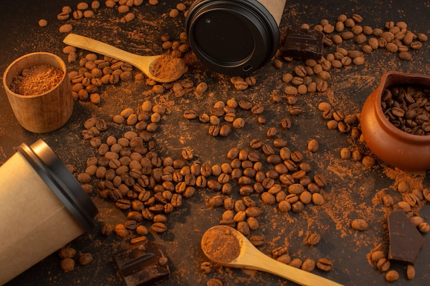 Une vue de dessus des graines de café brun avec des barres de chocolat et des tasses à café