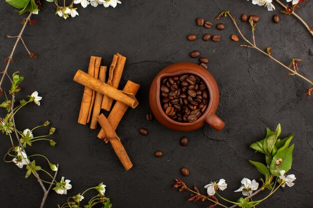 Vue de dessus des graines de café avec de la cannelle dans l'obscurité