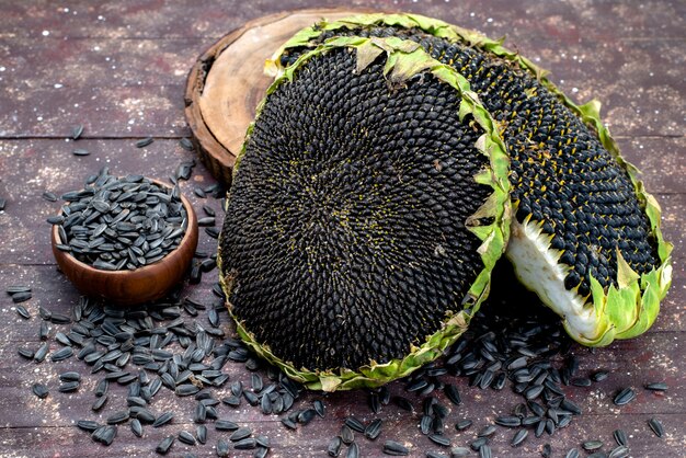 Une vue de dessus des graines de tournesol noir frais et savoureux sur le bureau brun granules de graines de tournesol