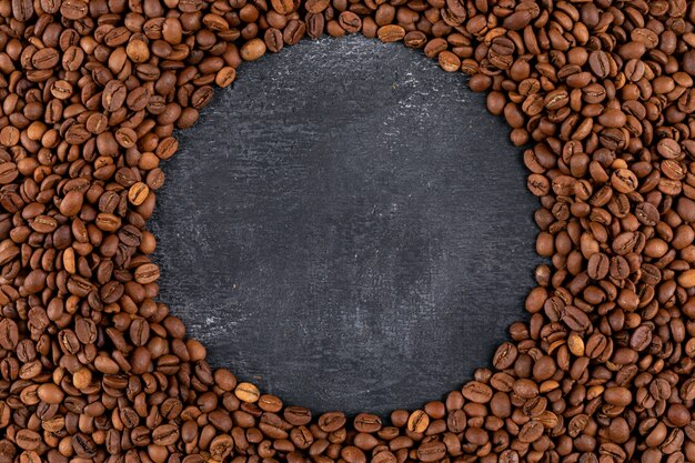 Vue de dessus des grains de café sur une surface sombre