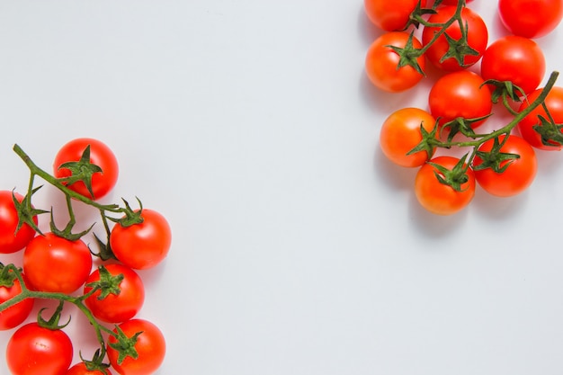 Vue de dessus des grappes de tomates sur fond blanc. espace horizontal pour le texte