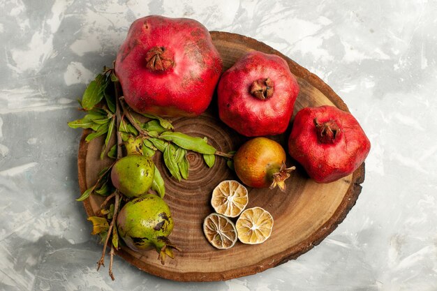 Photo gratuite vue de dessus grenades fraîches fruits moelleux juteux sur une surface blanche