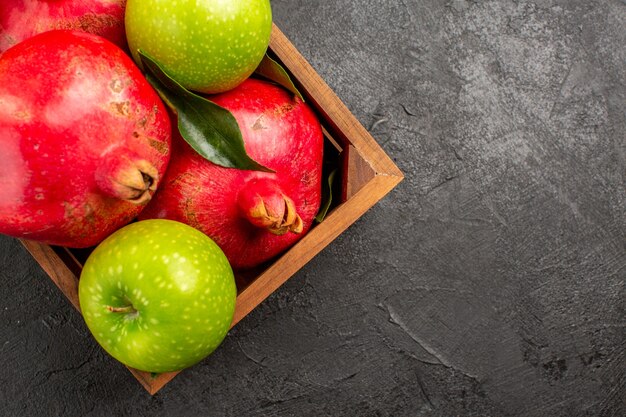 Vue de dessus des grenades rouges fraîches avec des pommes vertes sur la couleur des fruits mûrs de surface sombre